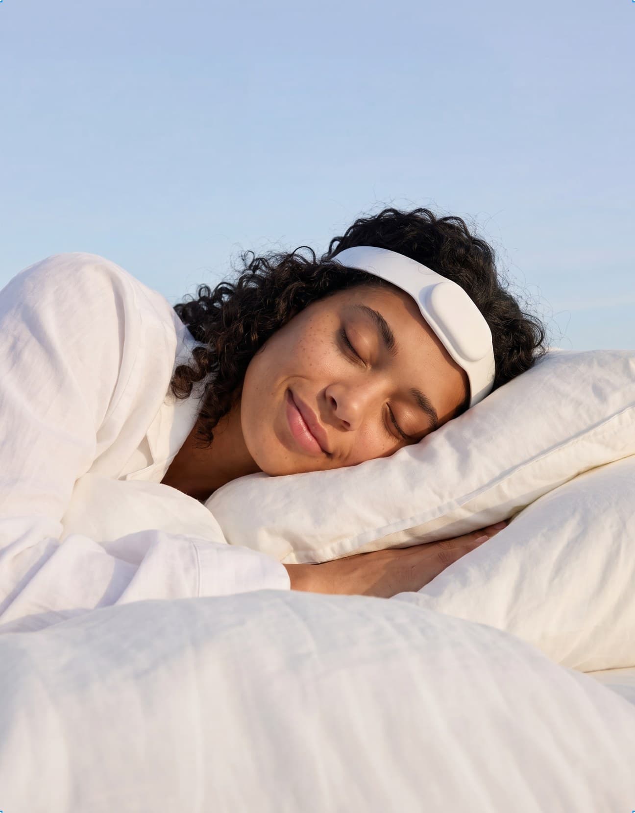 A woman asleep under an open sky, wearing the Paprika wearable.